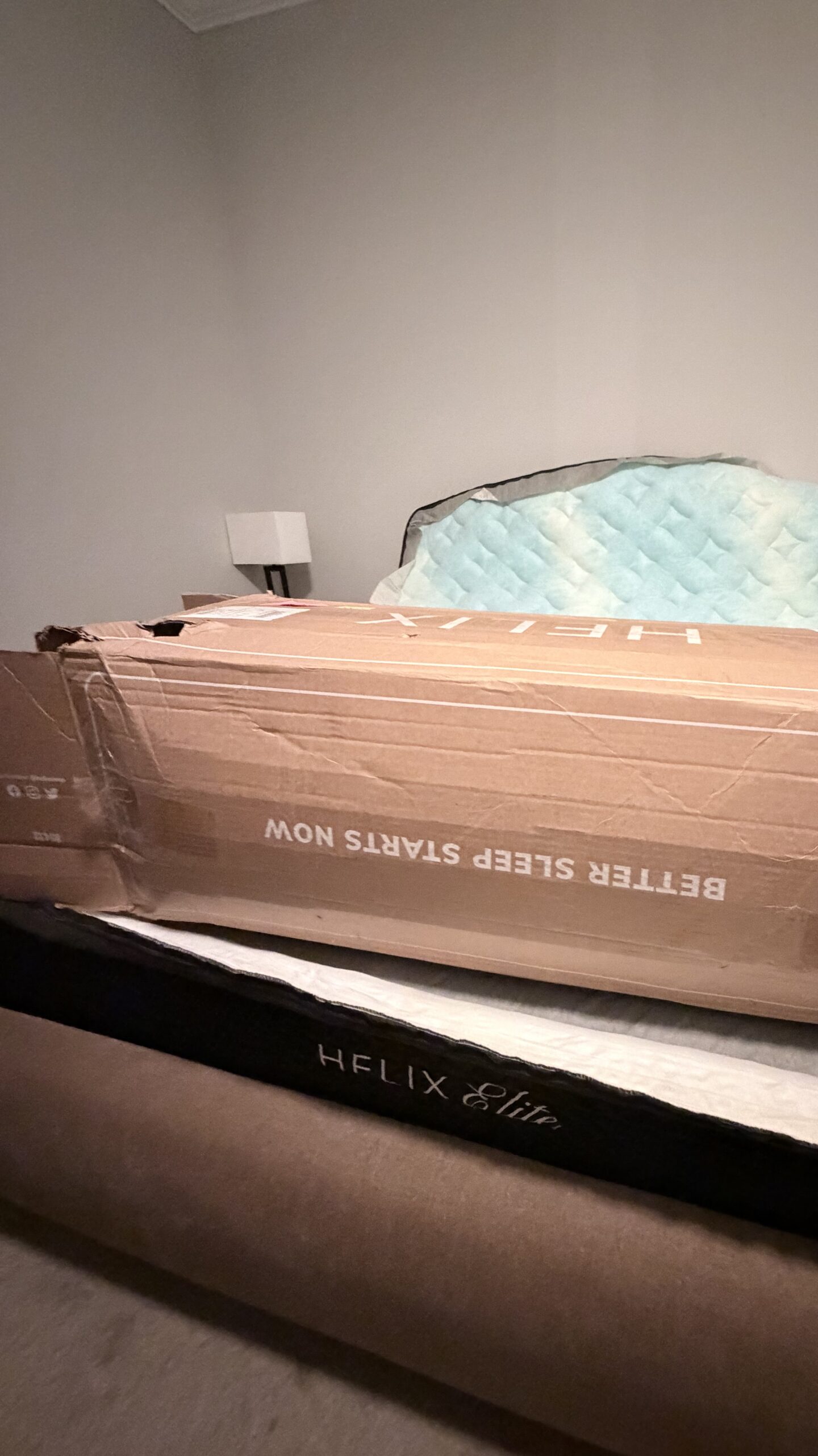 A Helix Midnight Elite mattress with the base installed and the secondary layer still in the box.